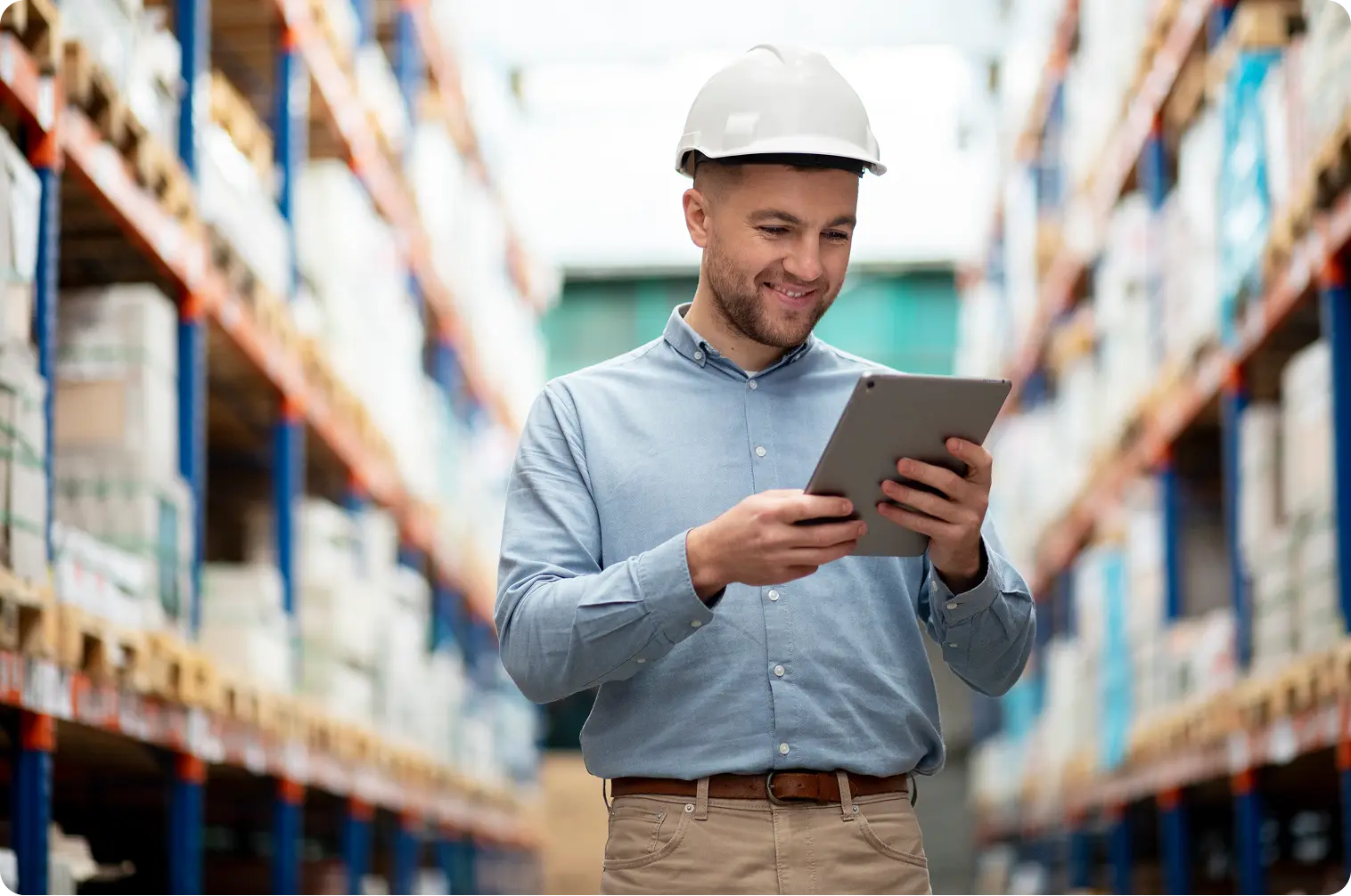 man-in-warehouse An employee looks at a tablet in a warehouse.